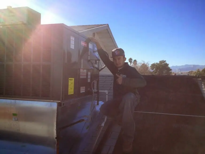 HVAC technician performing Heat Pump Repair on a rooftop unit in Nolanville